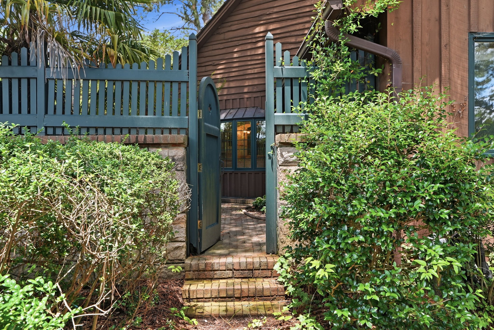 A blue garden gate and brick steps