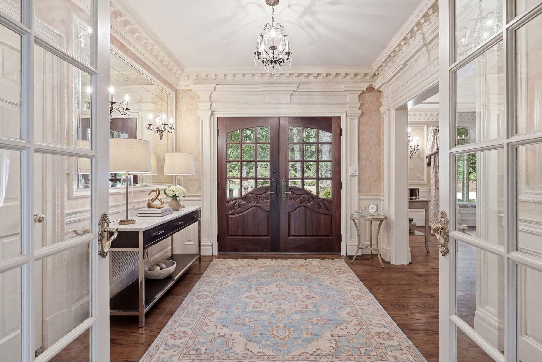 A formal entrance hall behind carved mahogany doors