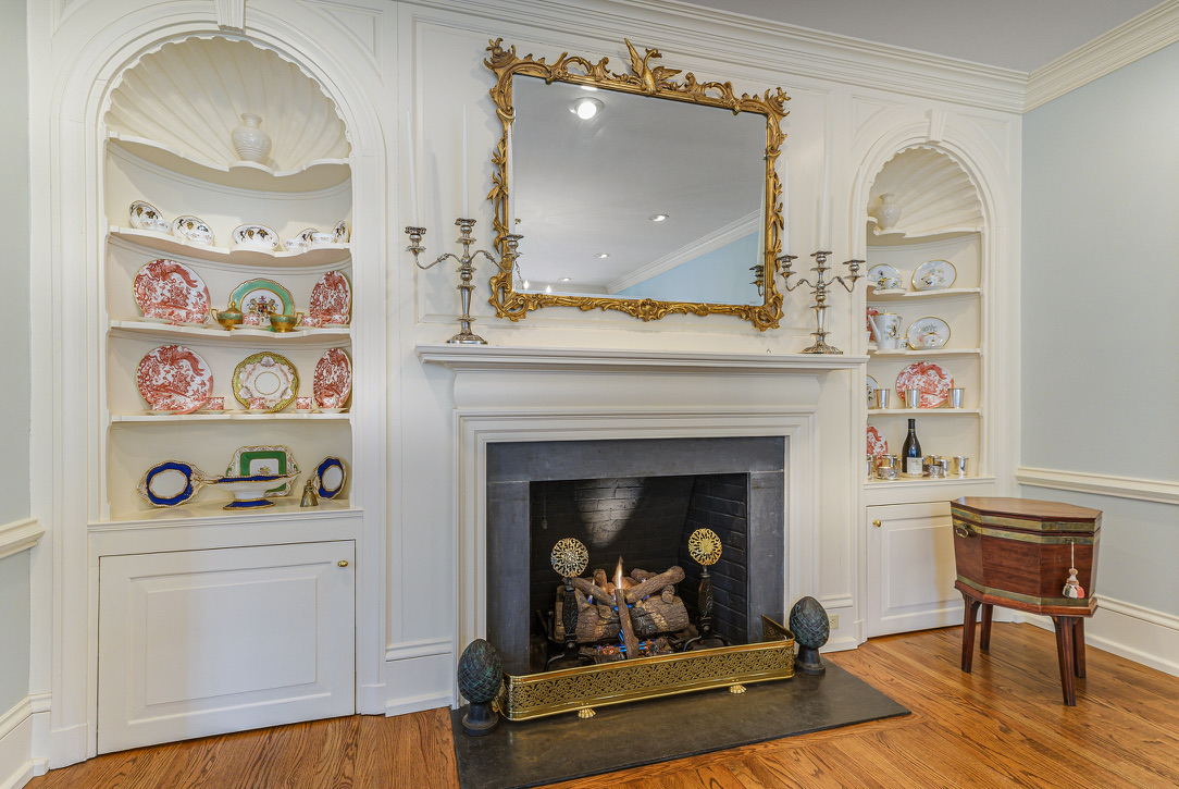 The original 1916 frontispiece, fire going, the shell cabinets flanking it