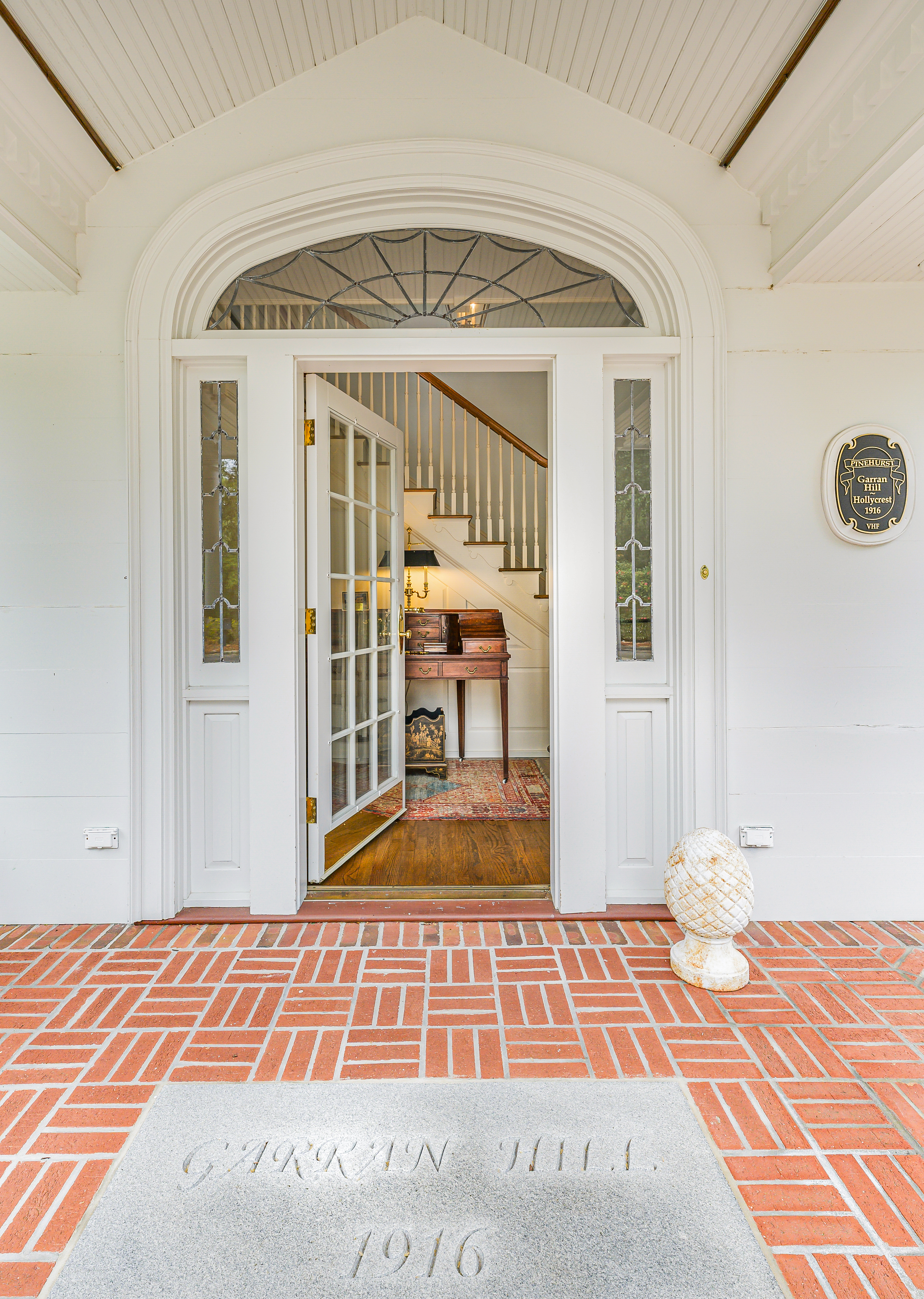 The Garran Hill threshold: the name and 1916 cut into the granite, the front door open to the staircase beyond